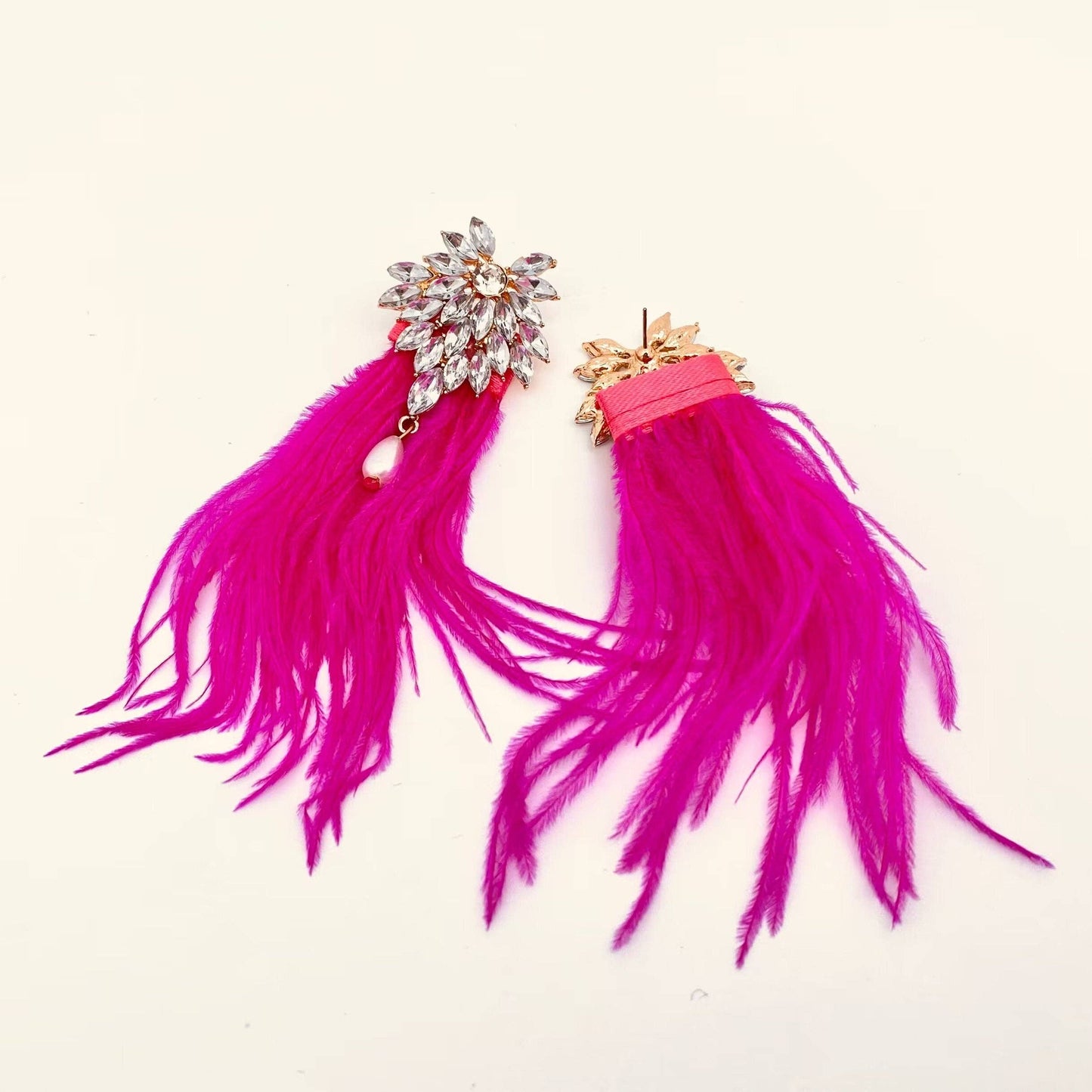 a pair of pink feather and rhinestone encrusted earrings