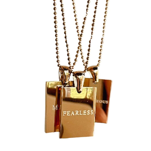 Gold pendant necklaces with FEARLESS engraved on it