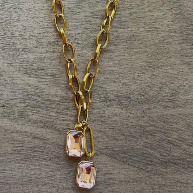 gold chain with two pink crystal pendants