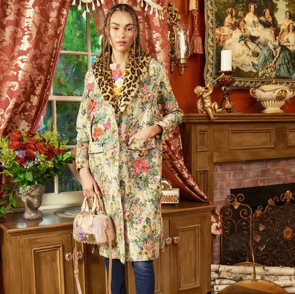 a model wearing a floral jacquard coat with faux leopard print collar in an indoor setting
