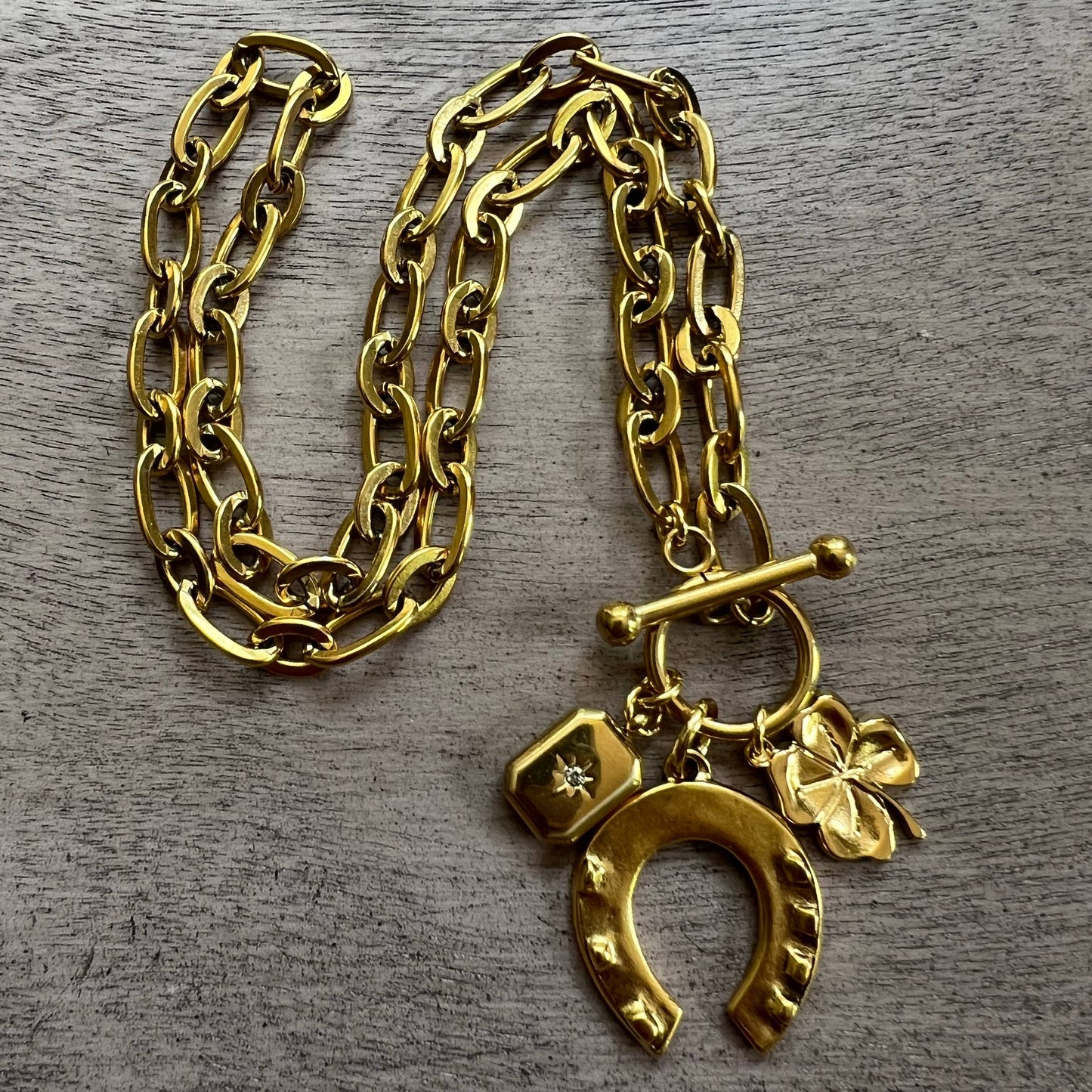 Gold multi charm necklace with horseshoe, clover, and pendant