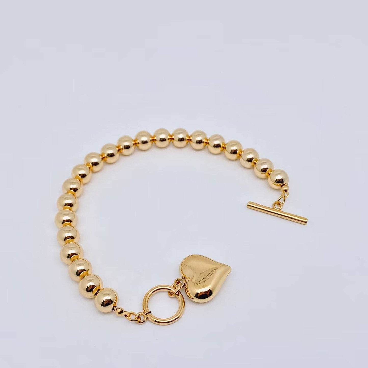 gold bead bracelet with puffy heart charm and toggle clasp