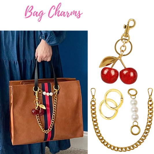 set of e bag charms including a gold chain, pearl chain, and large cherries on brown tote bag