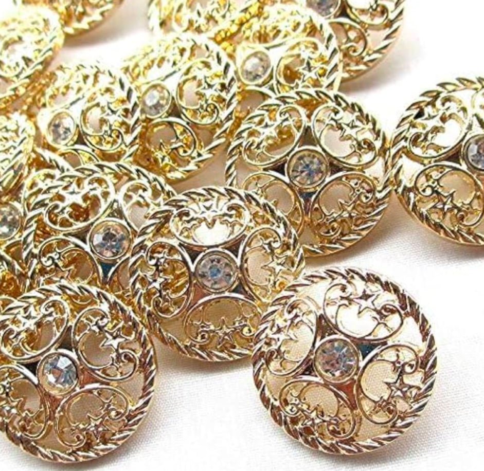 Gold buttons up close to show detailing against a white background