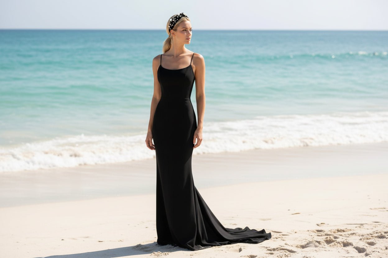 woman wearing a black headband with pearls and crystal embellishments and a black dress on the beach