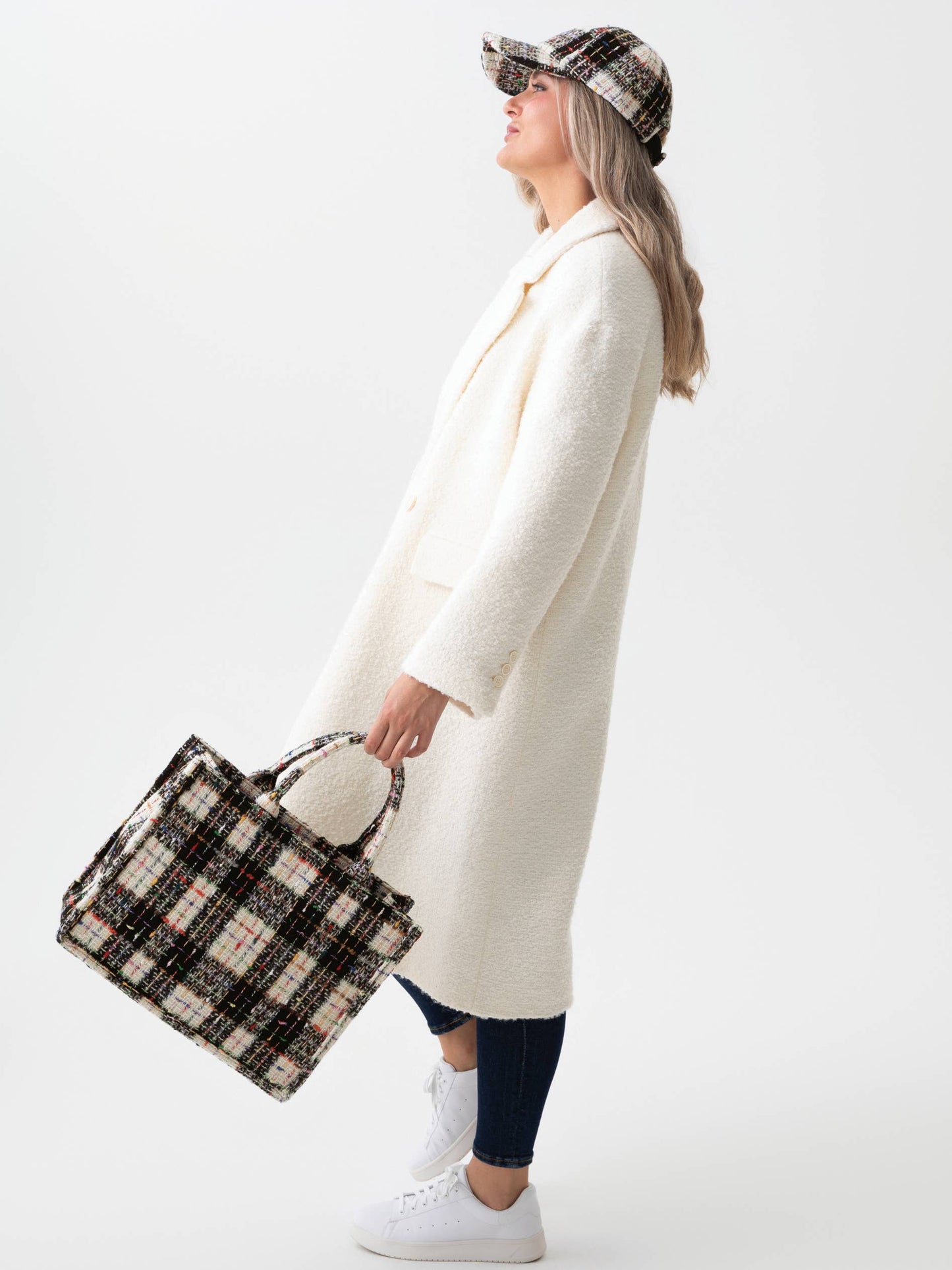 Woman holding black & white tweed tote bag