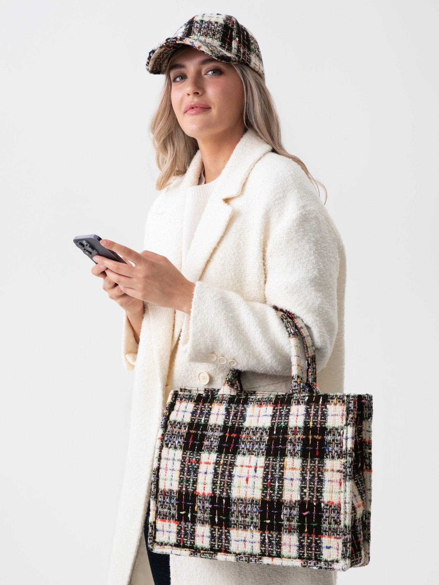 Woman holding black & white tweed tote bag in a lifestyle view