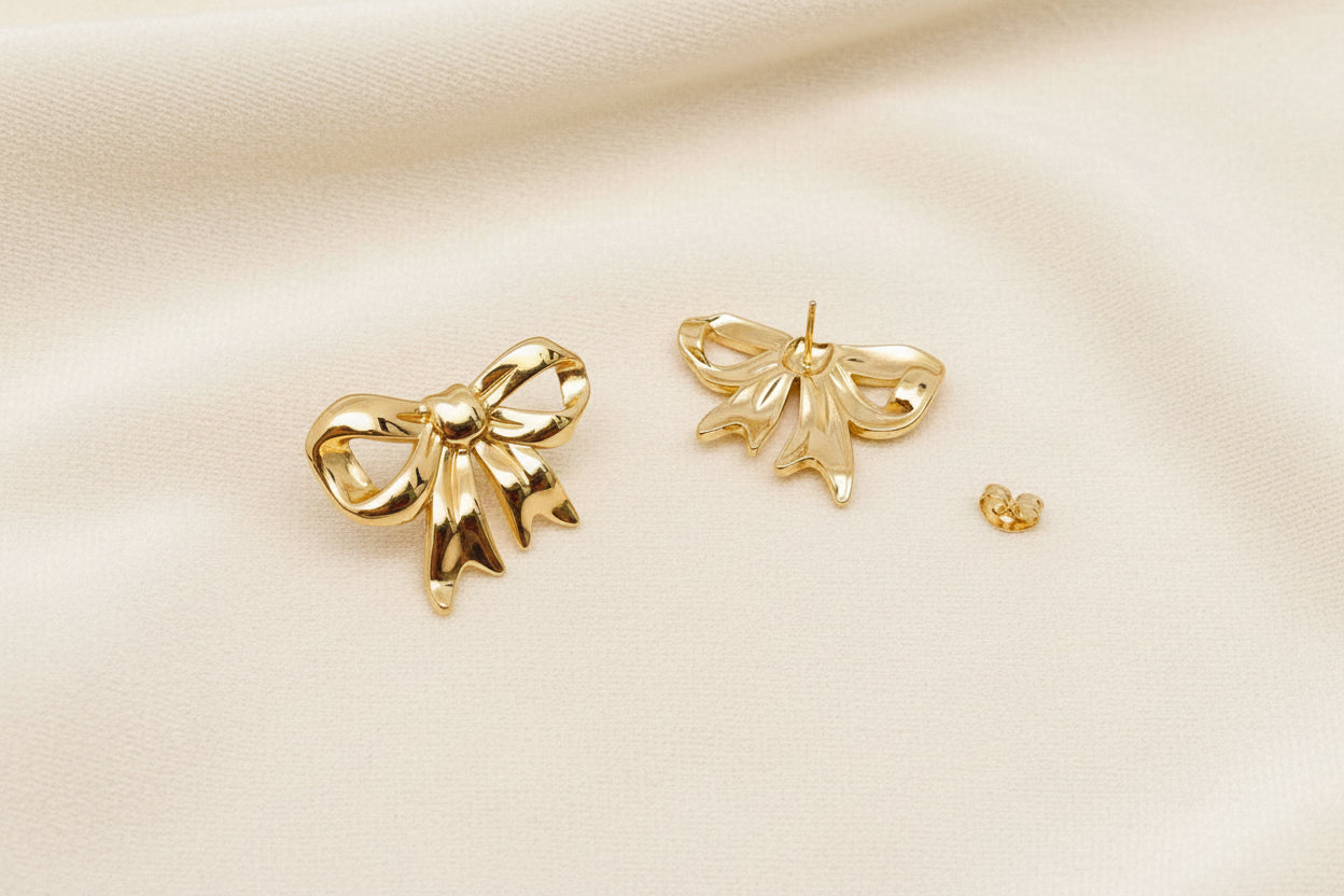 Front and back view of gold bow stud earrings showing post closure