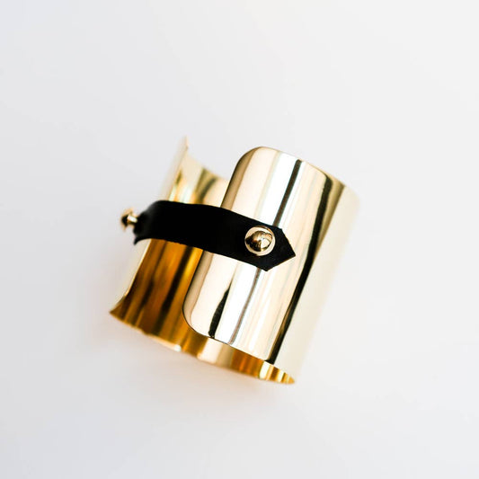 Brass cuff with black leather strap detail