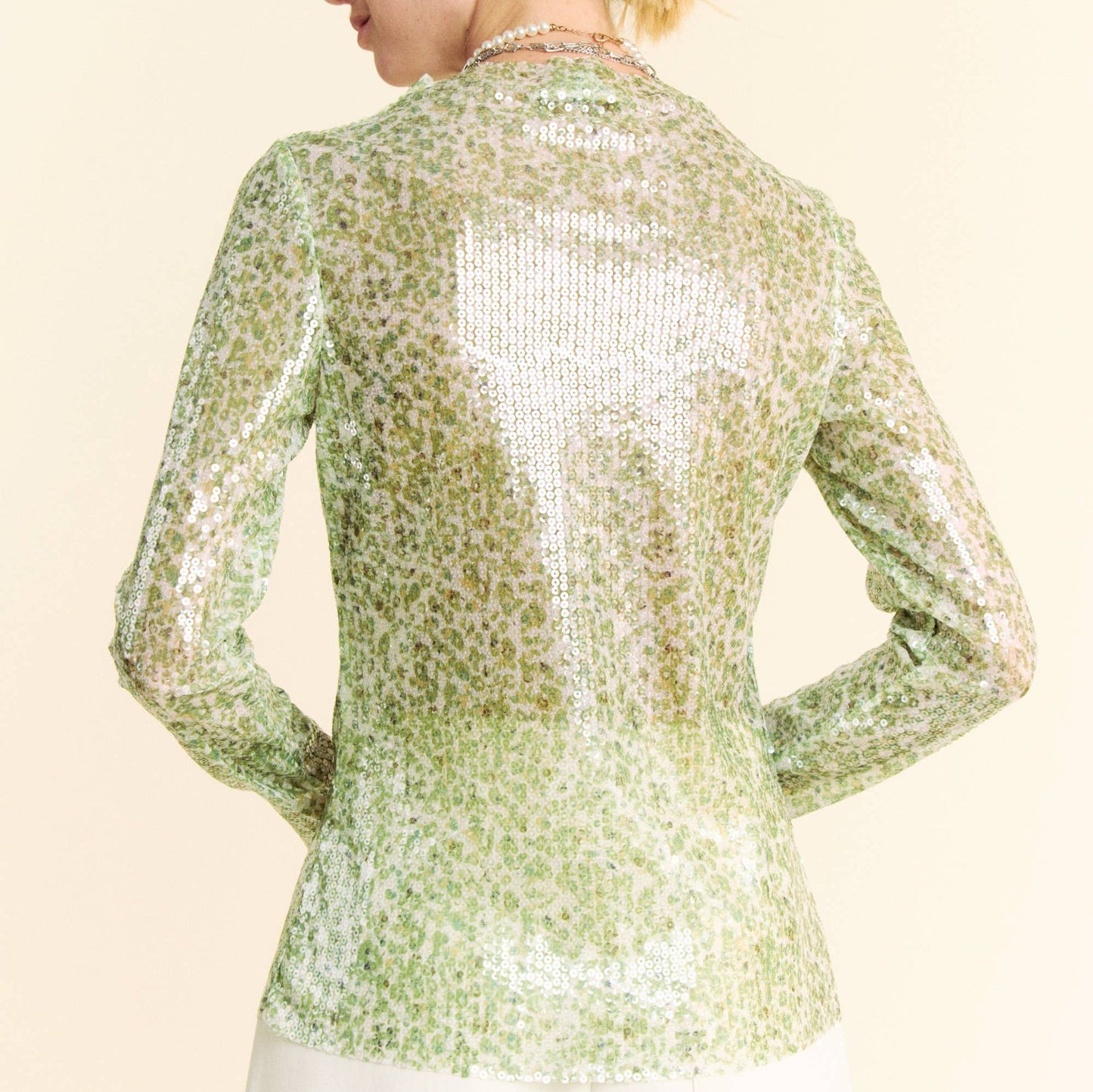 the back of a woman wearing a green sequin top