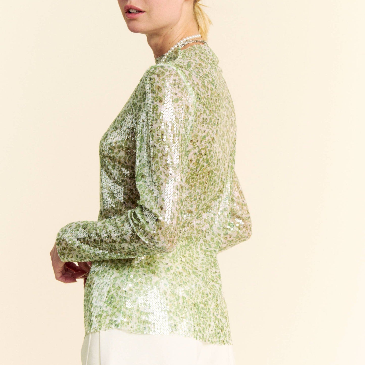 side profile view of a woman wearing a green sequin top