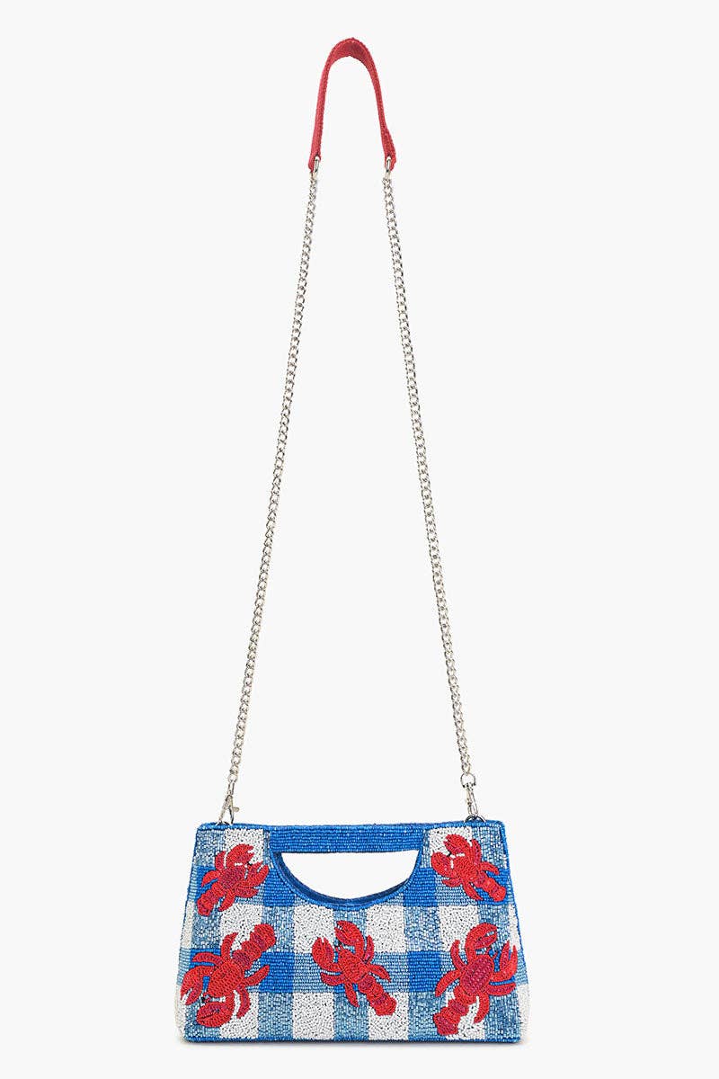 red sequin lobsters on a blue and white beaded bag with silver chain against a white background