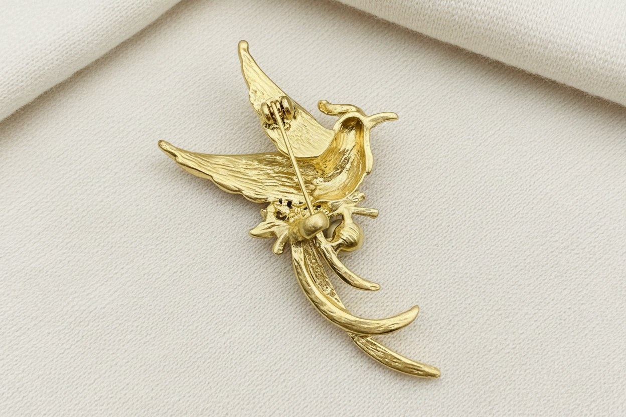 back view of songbird brooch to show the pin closure on a grey textured background