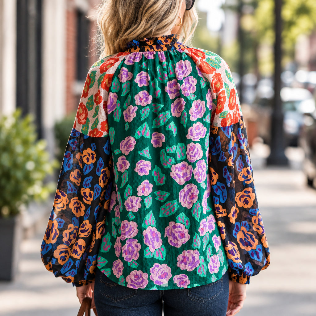 back view of a woman wearing a floral print blouse against an outdoor street setting