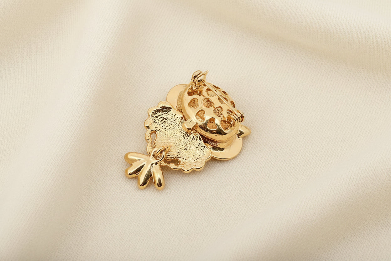 Gold charm shaped like a castle on a textured gray background
