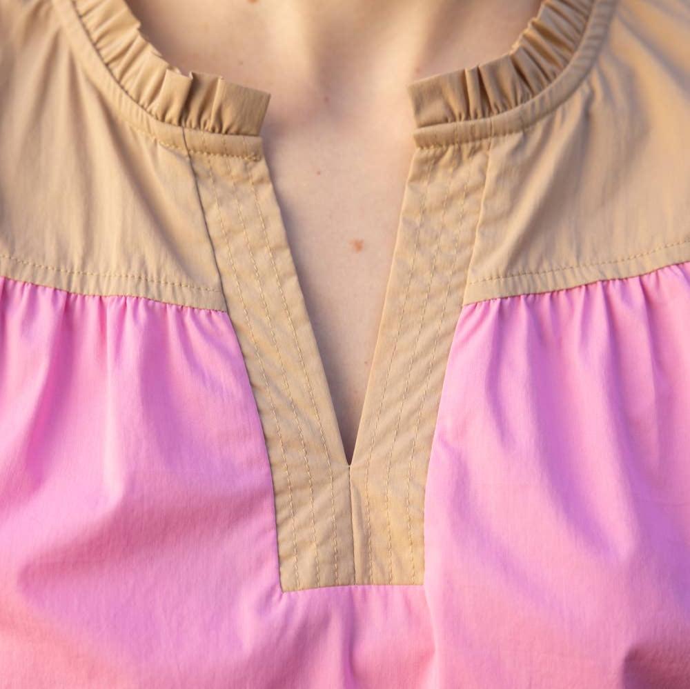 up close view of the neckline of a pink color block blouse