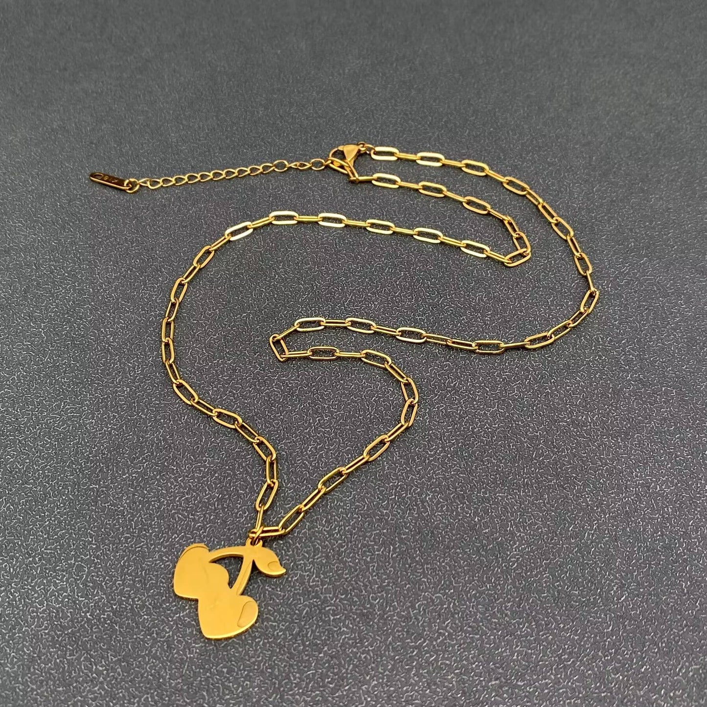 the back view of a cherry pendant necklace with gold chain