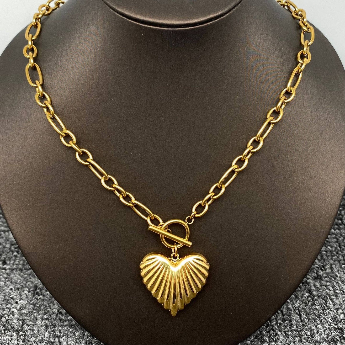 Close-up of gold puffy heart charm showing ribbed texture detail