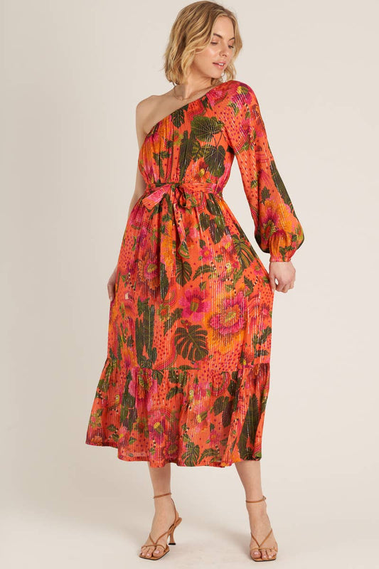 woman wearing a one shoulder orange tropical print dress and strappy heels