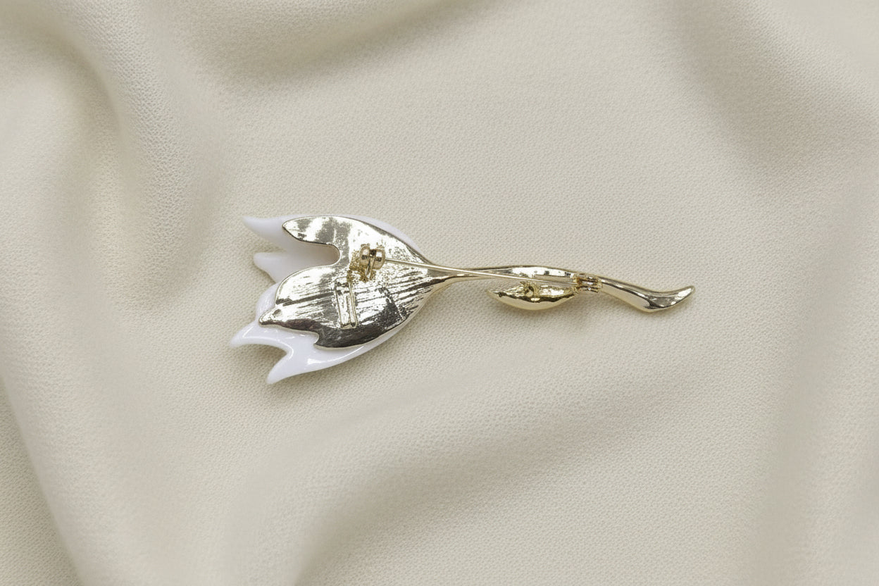 Gold tulip-shaped brooch on a light gray background