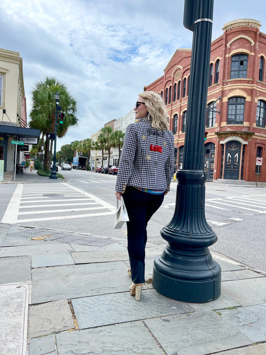 The back view of a woman standing on a street corner in downtown Charleston