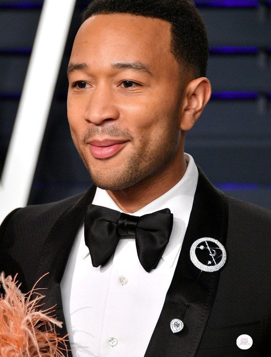 John Legend on the red carpet wearing a brooch on his lapel