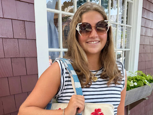 girl wearing brown cat eye sunglasses in an outdoor setting