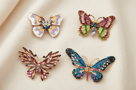 Southern garden brooches featuring 4 crystal and enamel butterfly brooches on an ivory fabric background