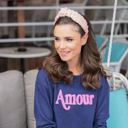 best headbands a style guide featuring a woman wearing a raffia knotted headband in an outdoor setting