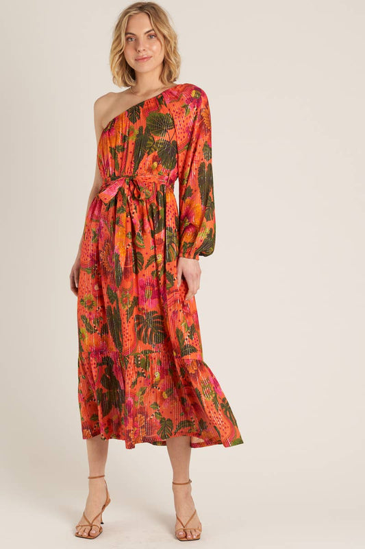 A woman wearing a one-shoulder orange tropical dress against a cream background