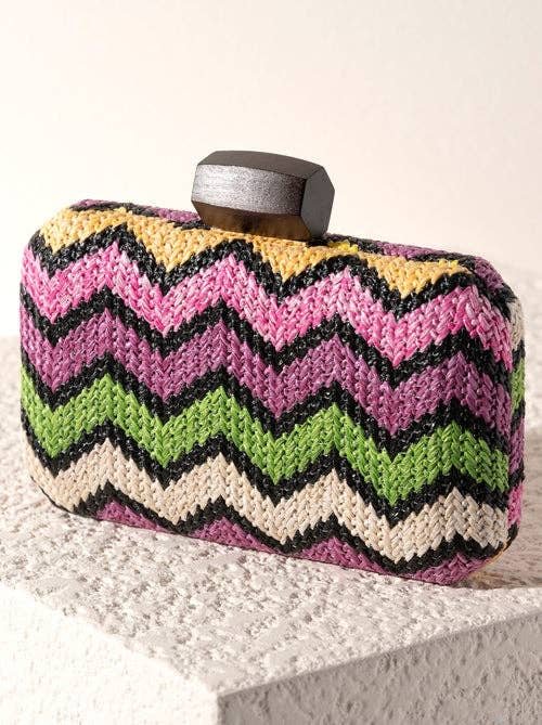 a chevron patterned clutch purse on an ivory textured surface