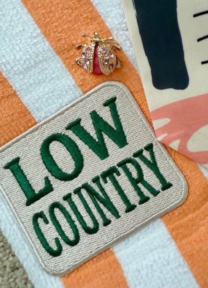 Patch with 'LOW COUNTRY' text on a striped terrycloth fabric background