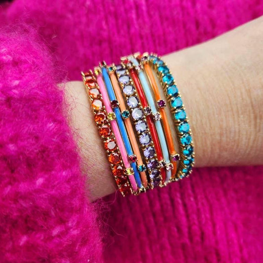 woman's arm and pink sweater with multiple multi colored enamel and crystal bracelets 