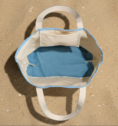 inside view of a beige and blue canvas bag on a gray background