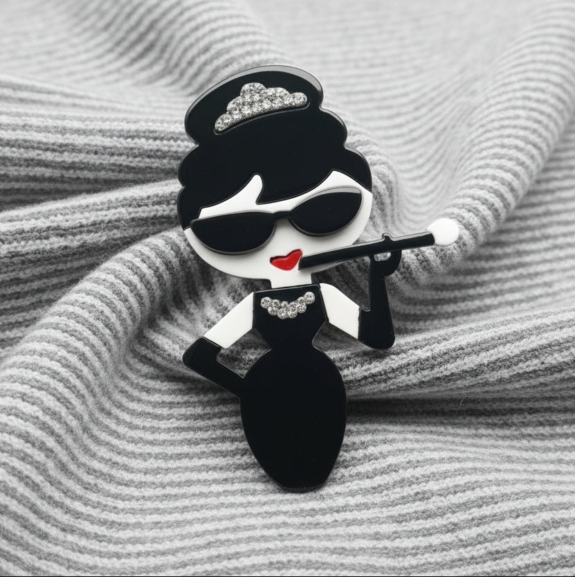 Audrey fashionista acrylic brooch pin on grey and white striped fabric. 