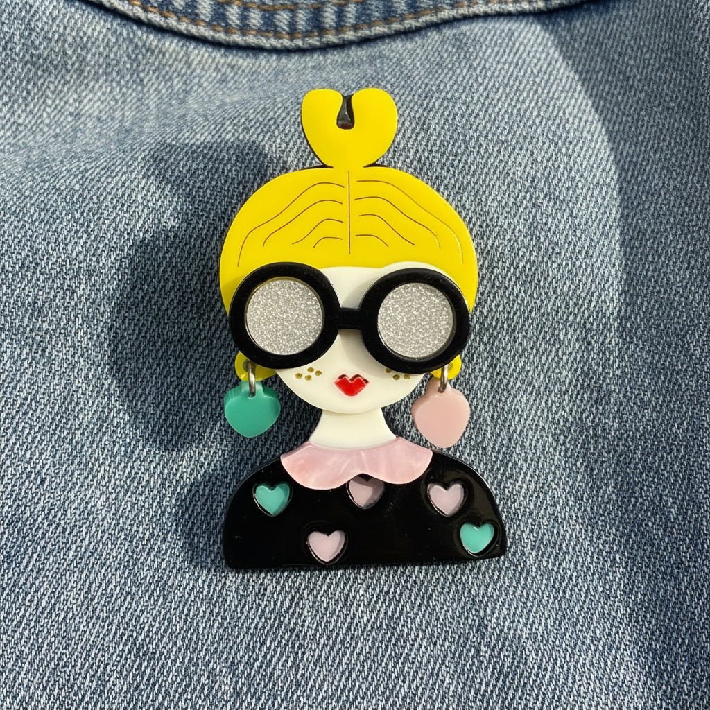 yellow hair fashionista brooch against a denim fabric background