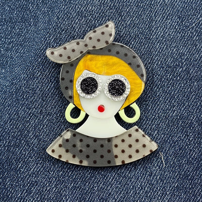 Fashionista brooch against denim fabric