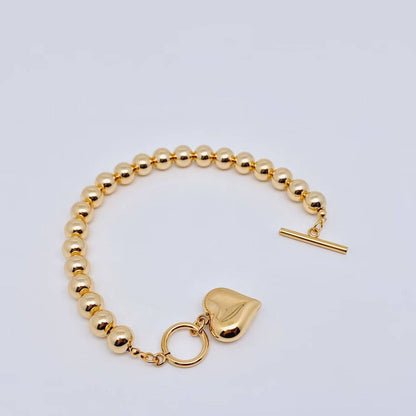gold bead bracelet with puffy heart charm and toggle clasp