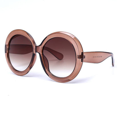 Round brown sunglasses against a white background