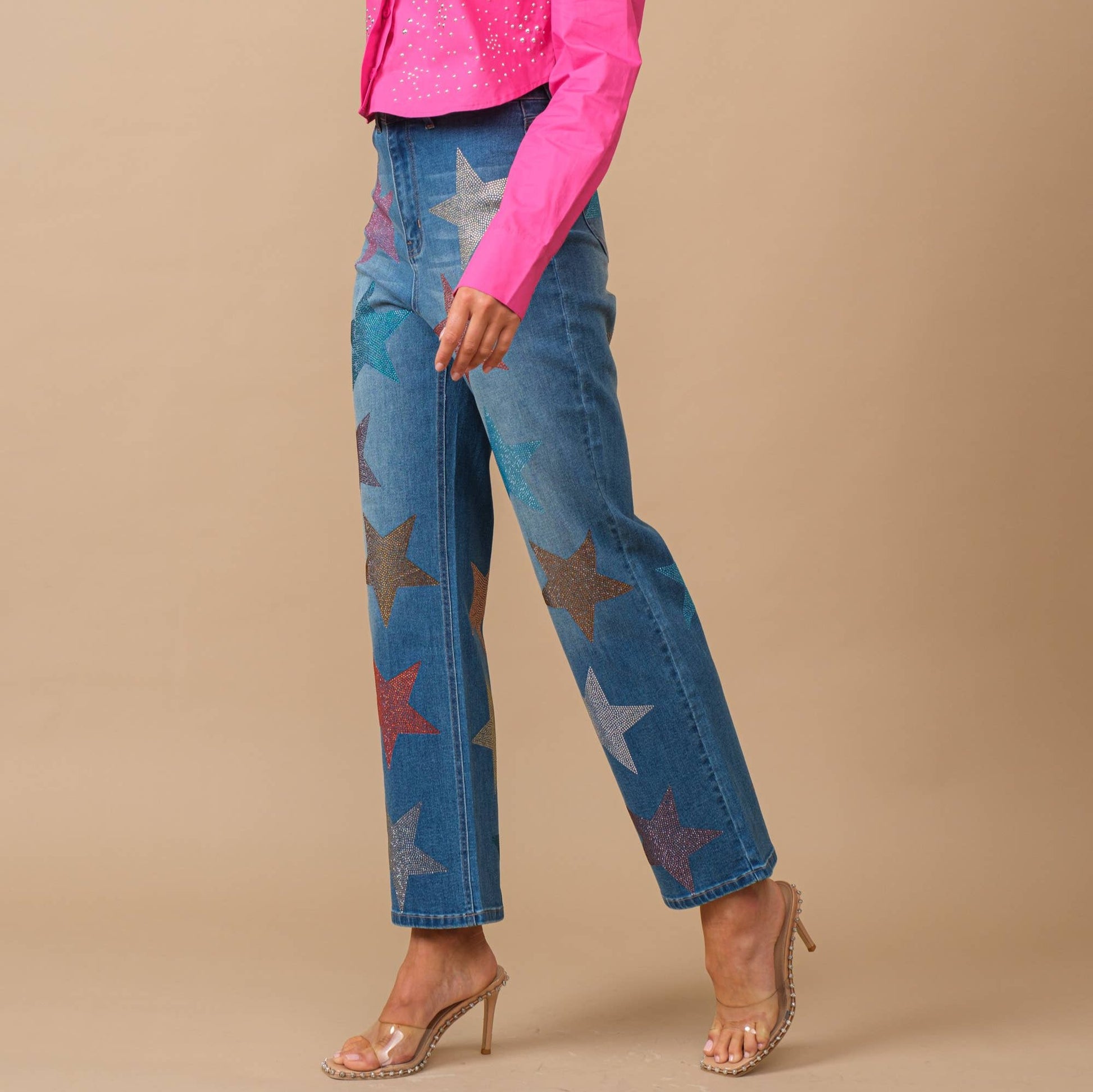 Woman in pink shirt wearing jeans with star shaped multi colored rhinestones 