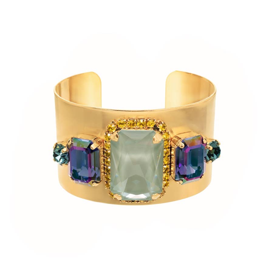Gold cuff bracelet with colorful gemstones on a white background