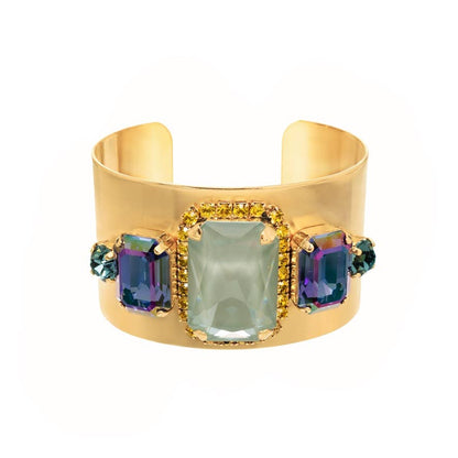 Gold cuff bracelet with colorful gemstones on a white background