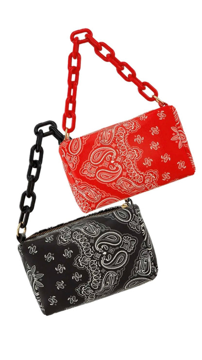 Two bandana-patterned handbags, one red and one black, on a white background.