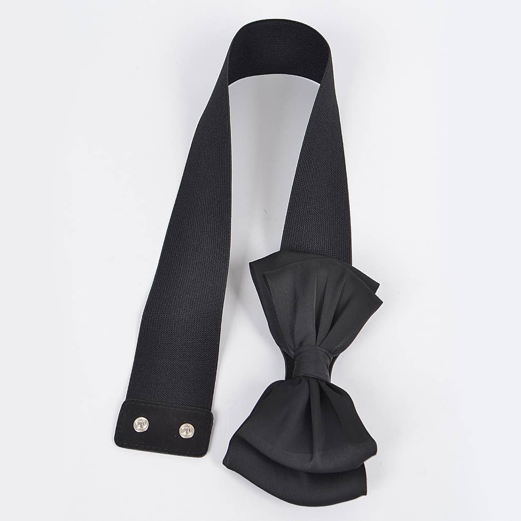 Flat lay of a black bow stretch belt showing the snap closure on a white surface