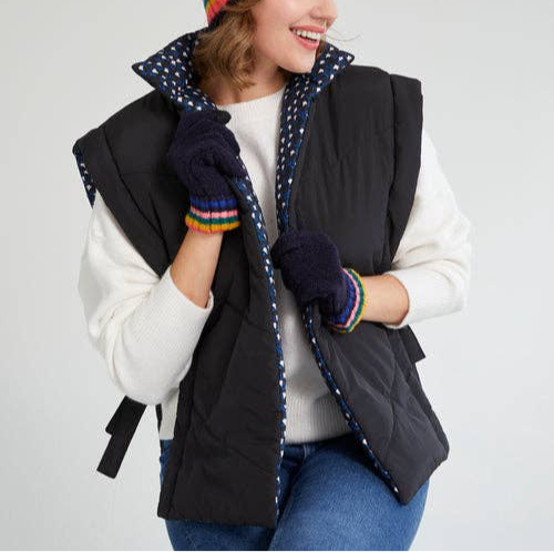 woman wearing black reversible side tie vest with white top, gloves, and jeans