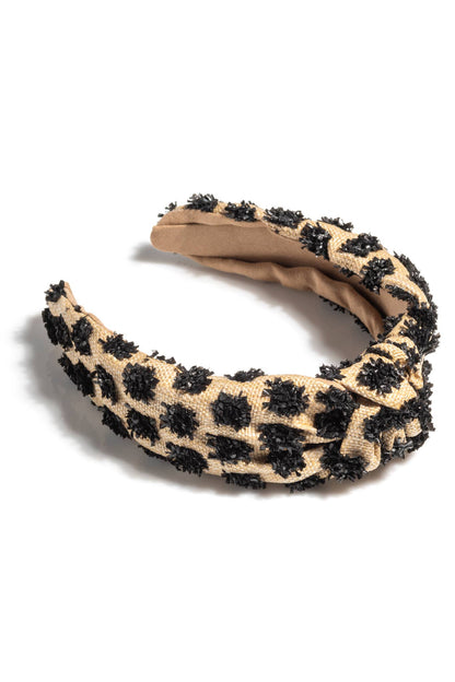 Tufted straw knotted headband in tan with black polka dot accents on white background