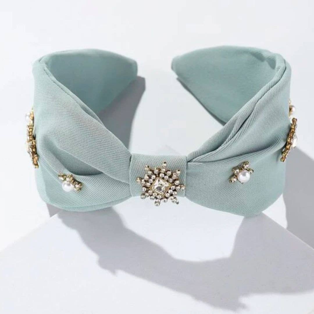 light blue crystal and pearl embellished headband against a white background