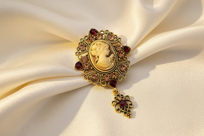 Decorative brooch with gemstones and a center cameo on an ivory fabric