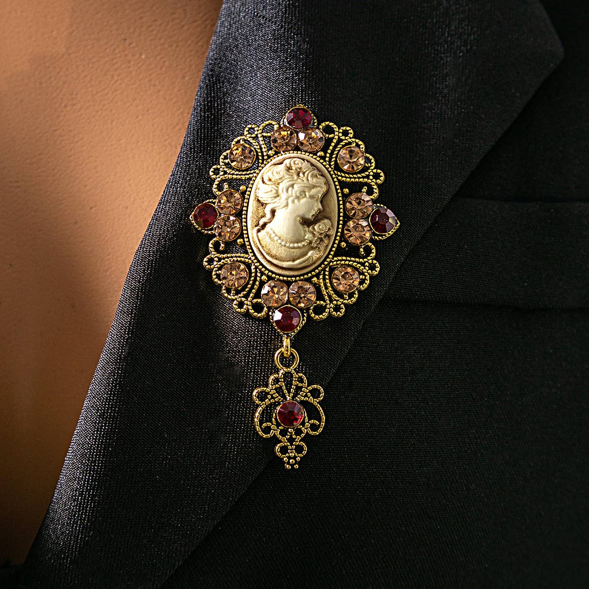 Decorative brooch with a cameo design and crystals on a black fabric background