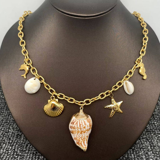 gold multi charm coastal themed charm necklace with 7 charms and a central conch shell